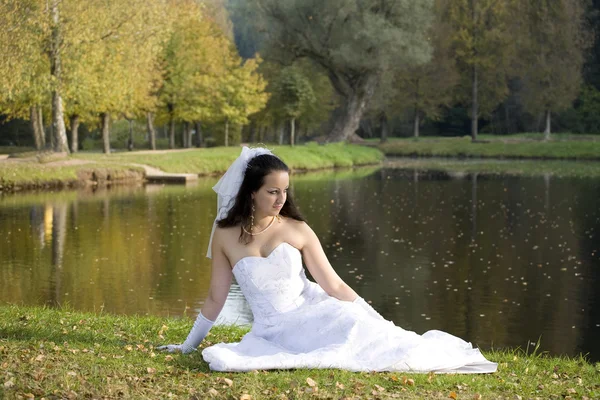 stock image A bride sitting next to the pond