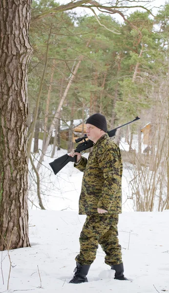 Lovec nebo vojáka v zasněženém lese — Stock fotografie