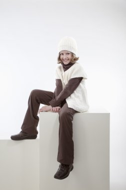 Girl sitting on a box, Mädchen sitzt lächelnd auf einer Kiste clipart