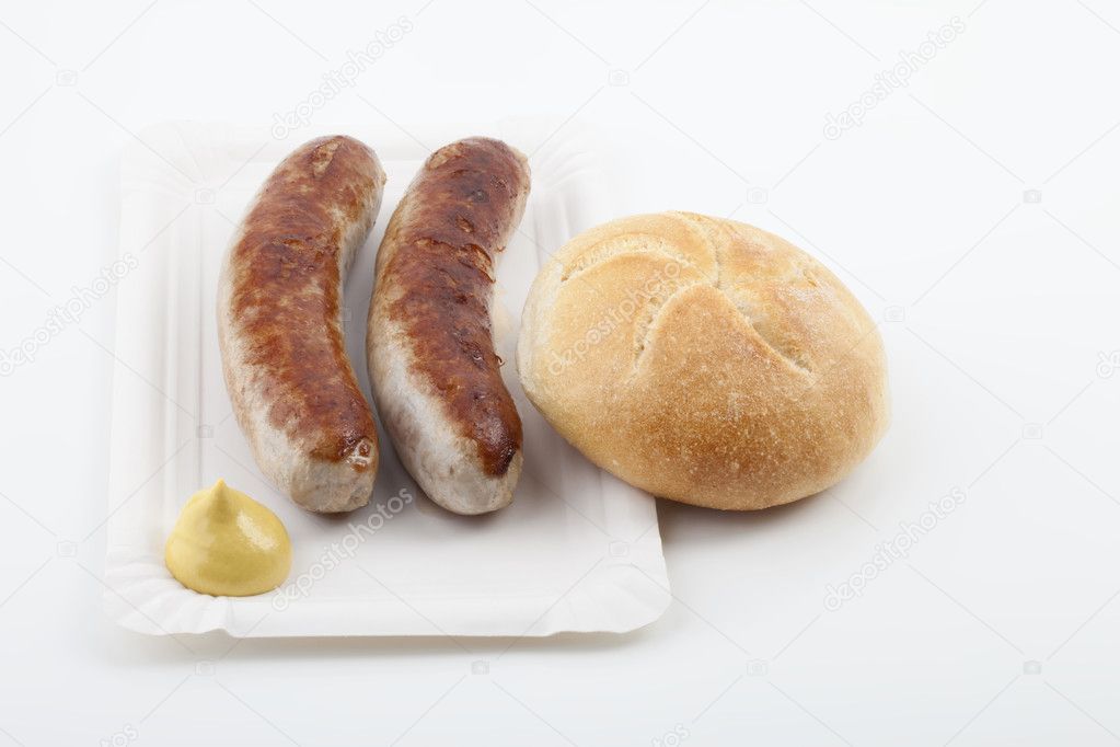 A pair of fried sausages with mustard, zwei Bratwürste mit Senf und Brötchen auf einem Pappteller