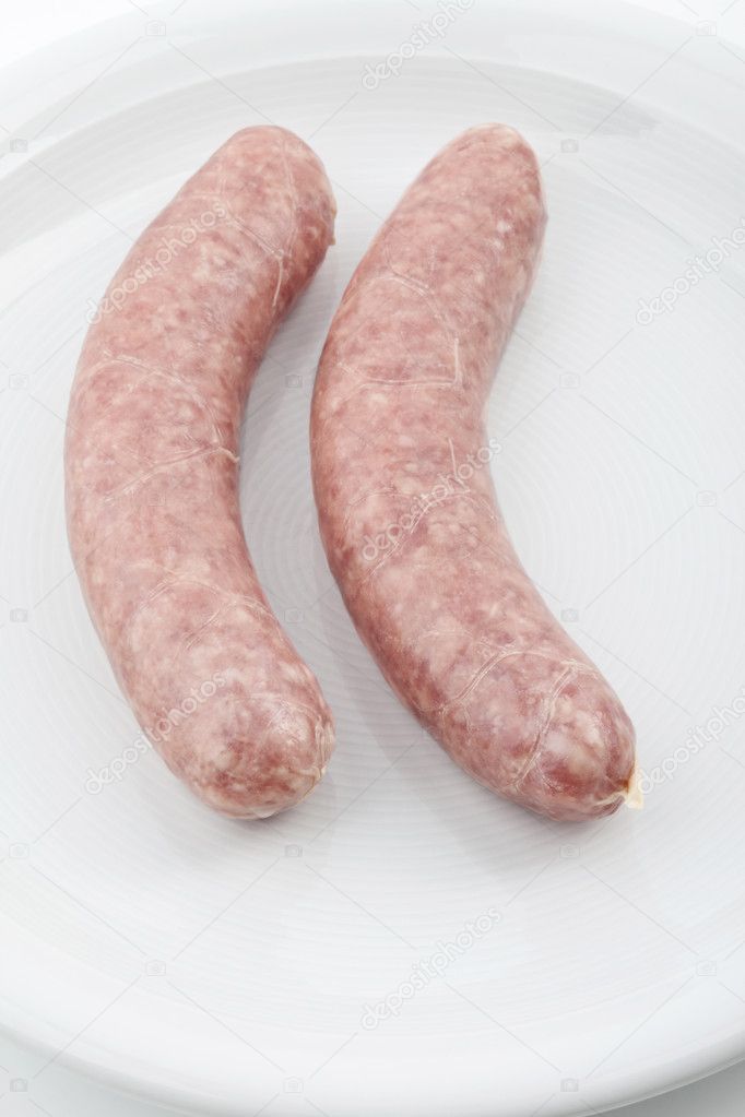 A pair of uncooked sausages on a plate, Ein Paar rohe Bratwürste auf einem Teller