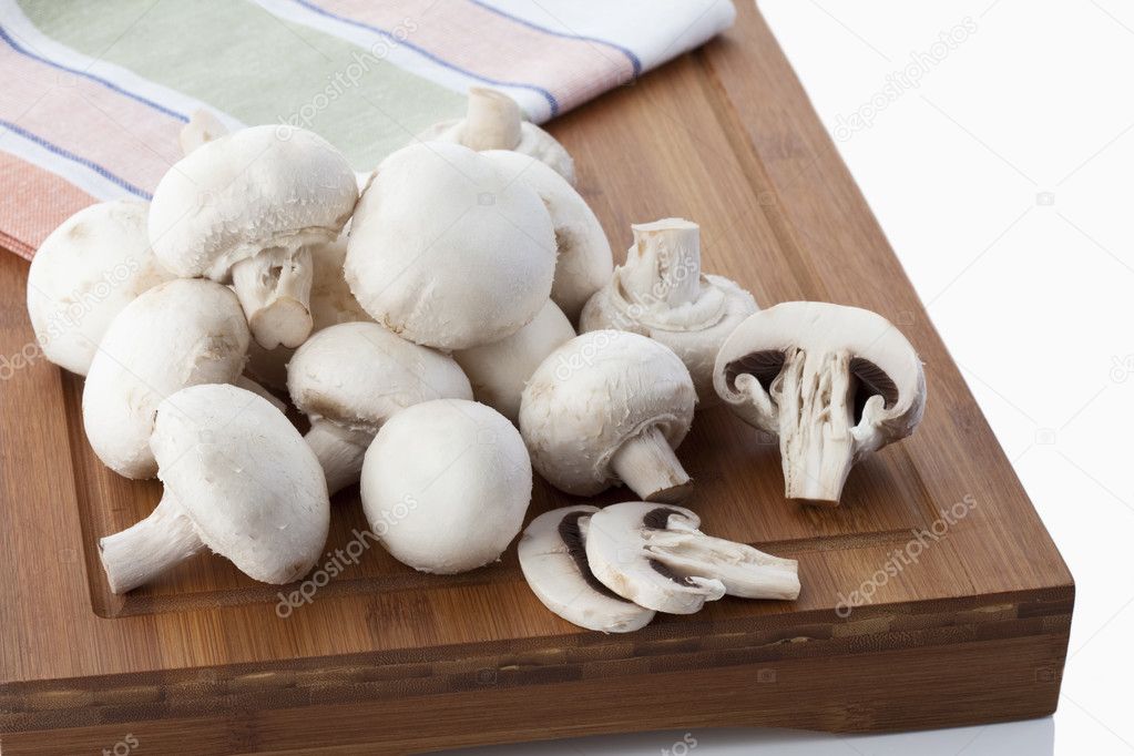 Frische Champignons, die auf einem Holzbrett liegen, fresh white mushrooms