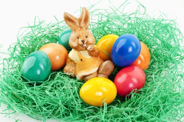 A easter bunny is sitting in a nest with eggs clipart