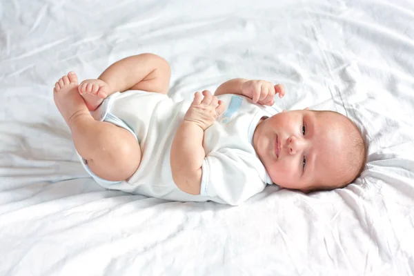 stock image Cute little child is lying on the sheet