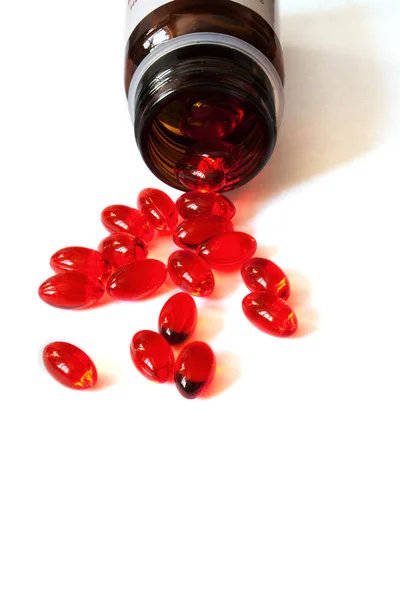 Pilules rouges sur une table blanche — Photo