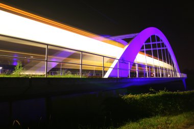 A light rail is passing an illuminated bridge near Stuttgart / Germany clipart