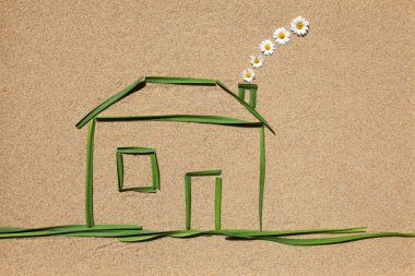 A house made of grass on a sandy background clipart