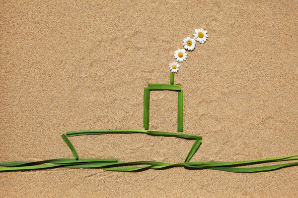 A boat made of grass on a sandy ground