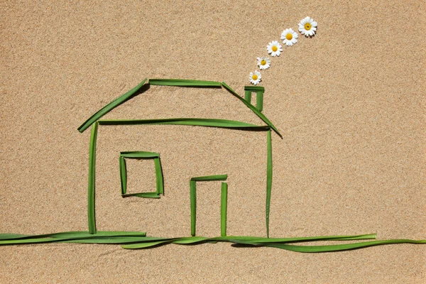 stock image A house made of grass on a sandy background