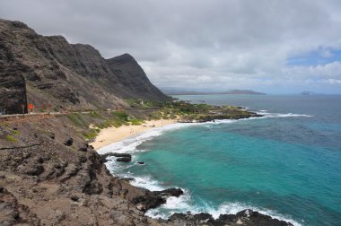 Felsenküste mit schmalem Sandstrand auf hawaii