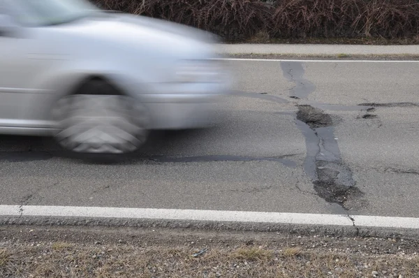 Car approaches pothole — Stock Photo, Image