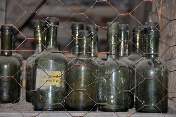 Old bottles in storage shelves — Stock Photo, Image