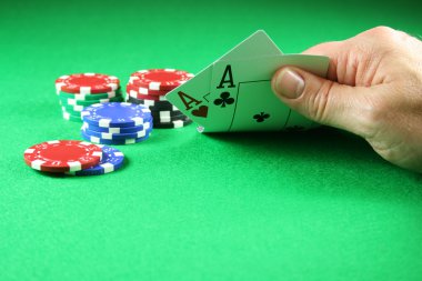 Bir çift as poker fişleri yanlarında ile gösterilen bir oyuncu