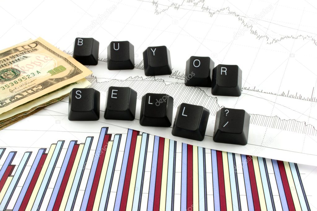 Business chart and graphs with US money and the words BUY OR SELL spelled out in keyboard letters