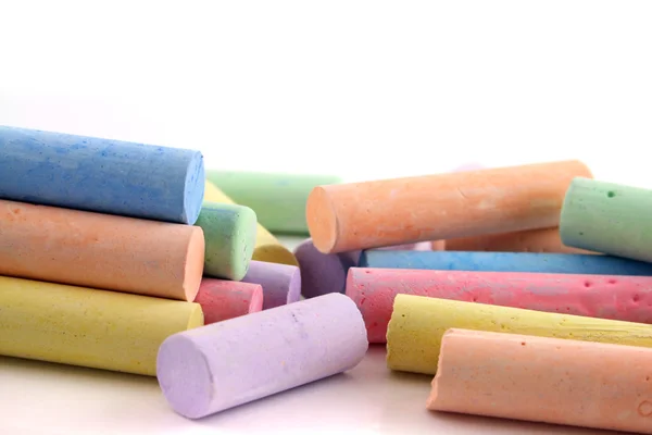 stock image Brightly colored chalks on a white reflective background