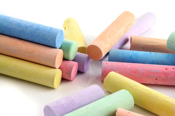 stock image Loads of brightly colored chalks on a white reflective background