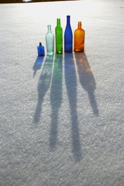 Colored bottles on snow clipart
