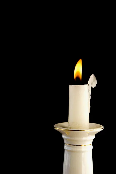 Bílý hořící svíčka v svícen — Stock fotografie