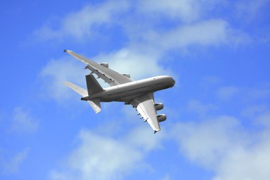 Passanger airliner flight over a cloud covered background clipart