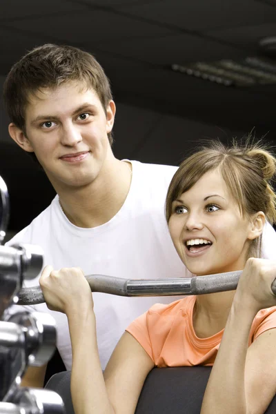 A girl's trainer shows her the correct form of exercise — Stock Photo, Image