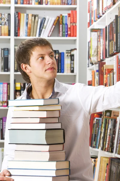Mladý muž výběru knih — Stock fotografie