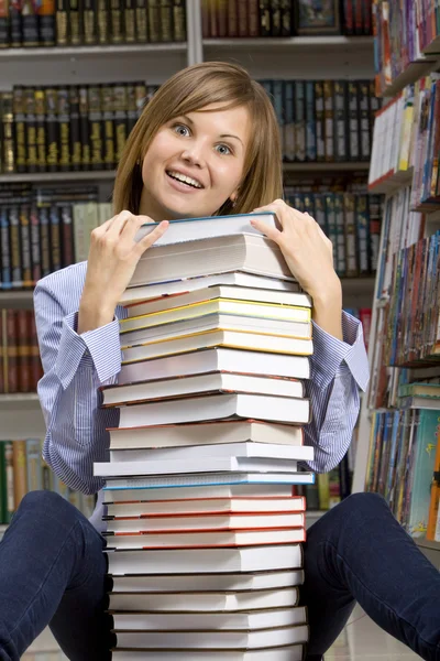 Žena sedí s Stoh knih — Stock fotografie