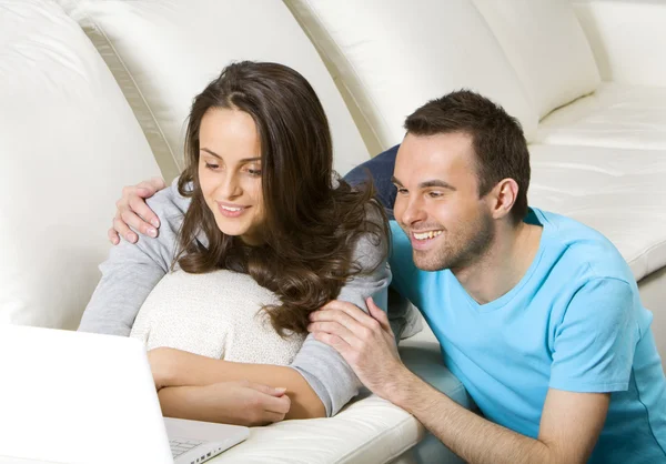 Feliz pareja joven con ordenador portátil Fotos de stock