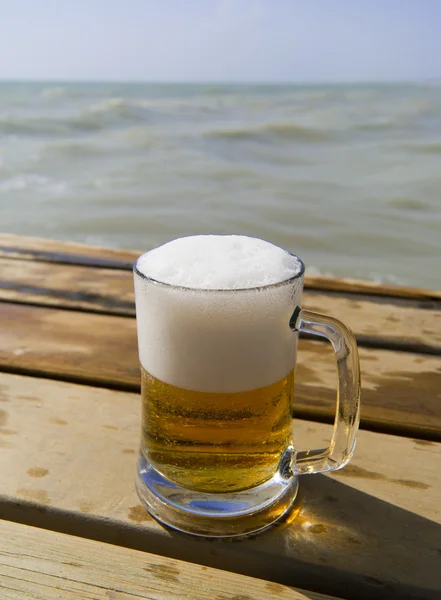 Mug of fresh beer on the wooden pier — Stock Photo, Image