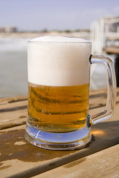 Mug of beer on the wooden pier Stock Picture