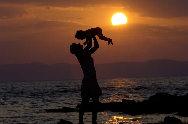 Μητέρα με το παιδί στο ηλιοβασίλεμα Εικόνα Αρχείου