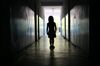 Silhouette of the little girl in a long corridor clipart