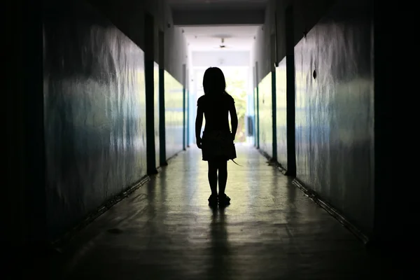 Силуэт маленькой девочки в длинном коридоре — стоковое фото