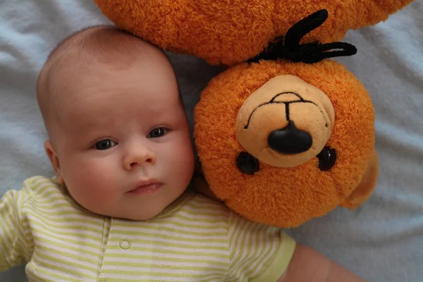 De baby en een teddybeer — Stockfoto