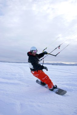 bir adam kar snowboard yaparken kışın uçurtmalar..