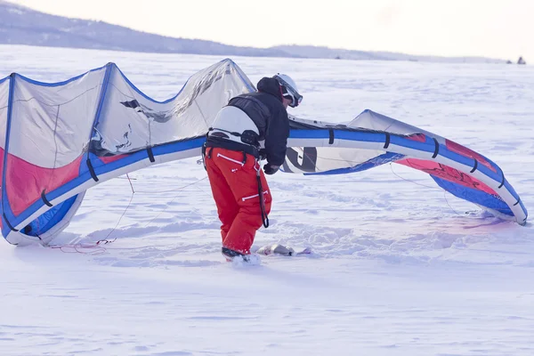 一名男子在风筝上他的滑雪板之前调整他的雪风筝 — 图库照片