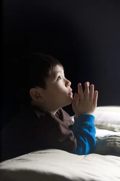 若い男の子は彼の就寝前に彼の祈りを言う — ストック写真