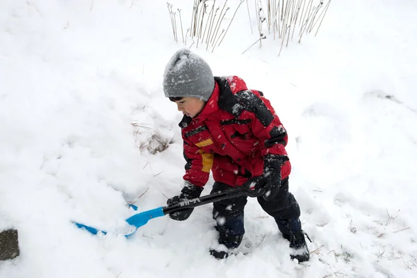 いくつかの雪をシャベルで働いている若い男の子 — ストック写真