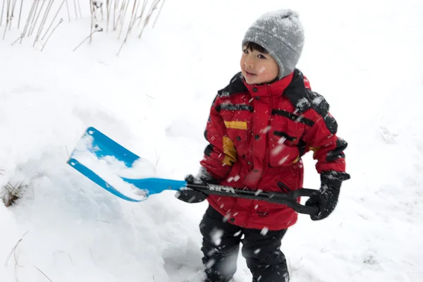 Junge schaufelt Schnee. — Stockfoto