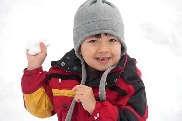 若い男の子は雪だるまを保持し 彼はそれをスローするように準備ができているように見えます — ストック写真