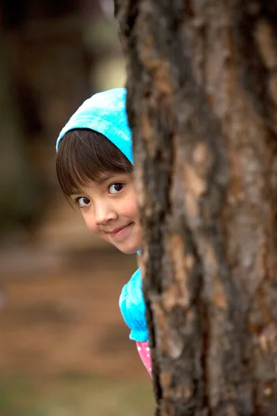 Girl peeks from tree. — Stock Photo, Image