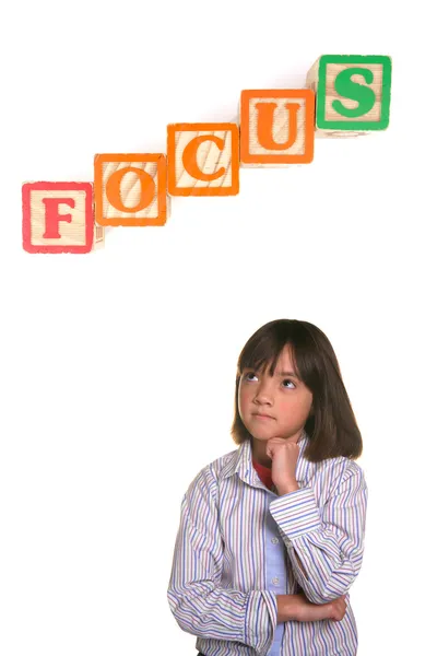 Stock image A young student strikes a focused posture with word block above.