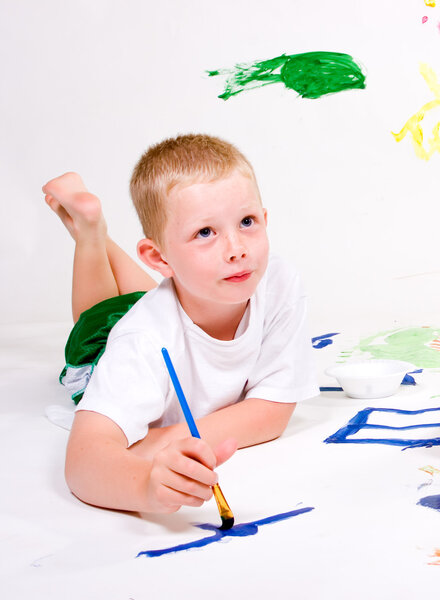 A boy thinks of what he is going to paint next.