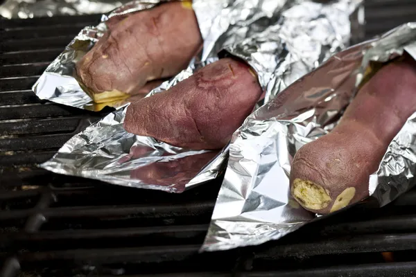 在燃气烧烤炉烹饪红薯裹在锡纸 — 图库照片