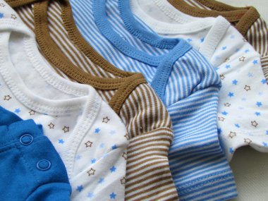 Baby bodysuits of different colors clipart