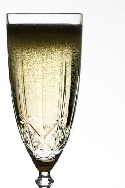 Champagne in an elegant cut crystal champage flut against a white background clipart