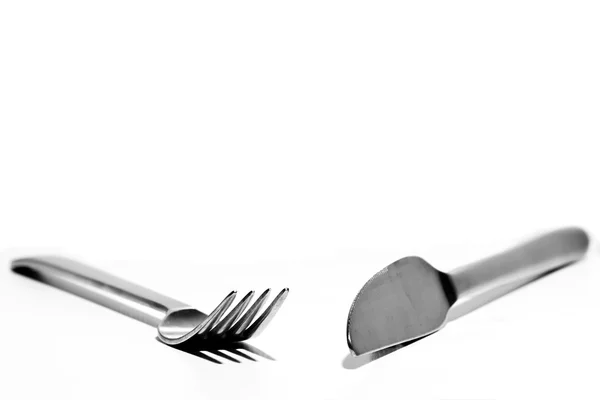 stock image A knife and fork angles towards each other on a white background