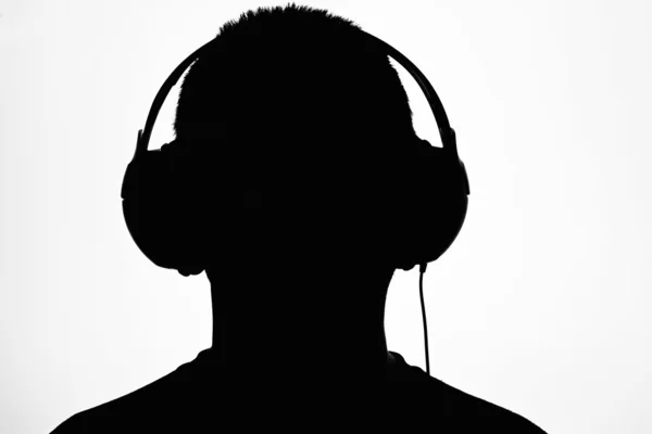 stock image A man listing to music, in silhouette