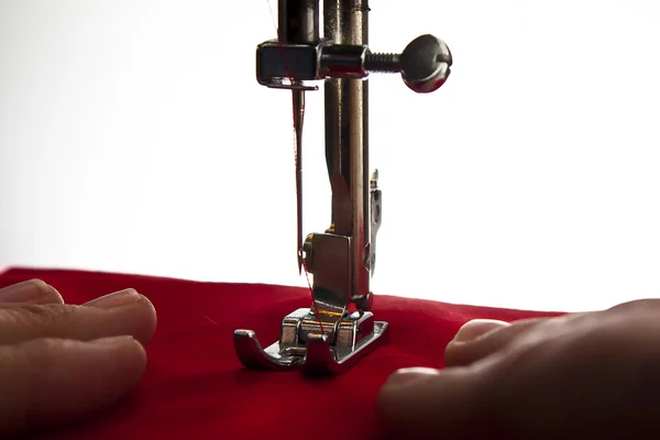 Maszyna do szycia za pomocą czerwonego materiału — Zdjęcie stockowe