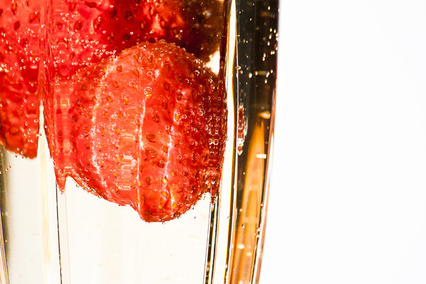 Champagne poured over strawberries in an elegant cut crystal champagne glass