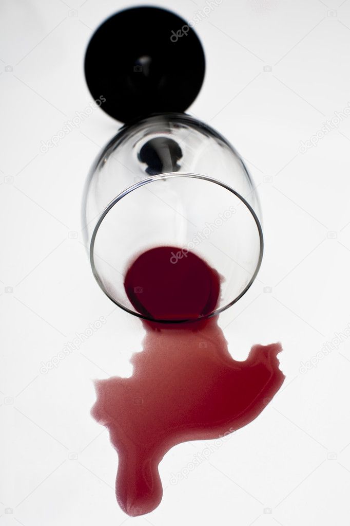 Red wine that has been split for a knocked over wine glass on a white table